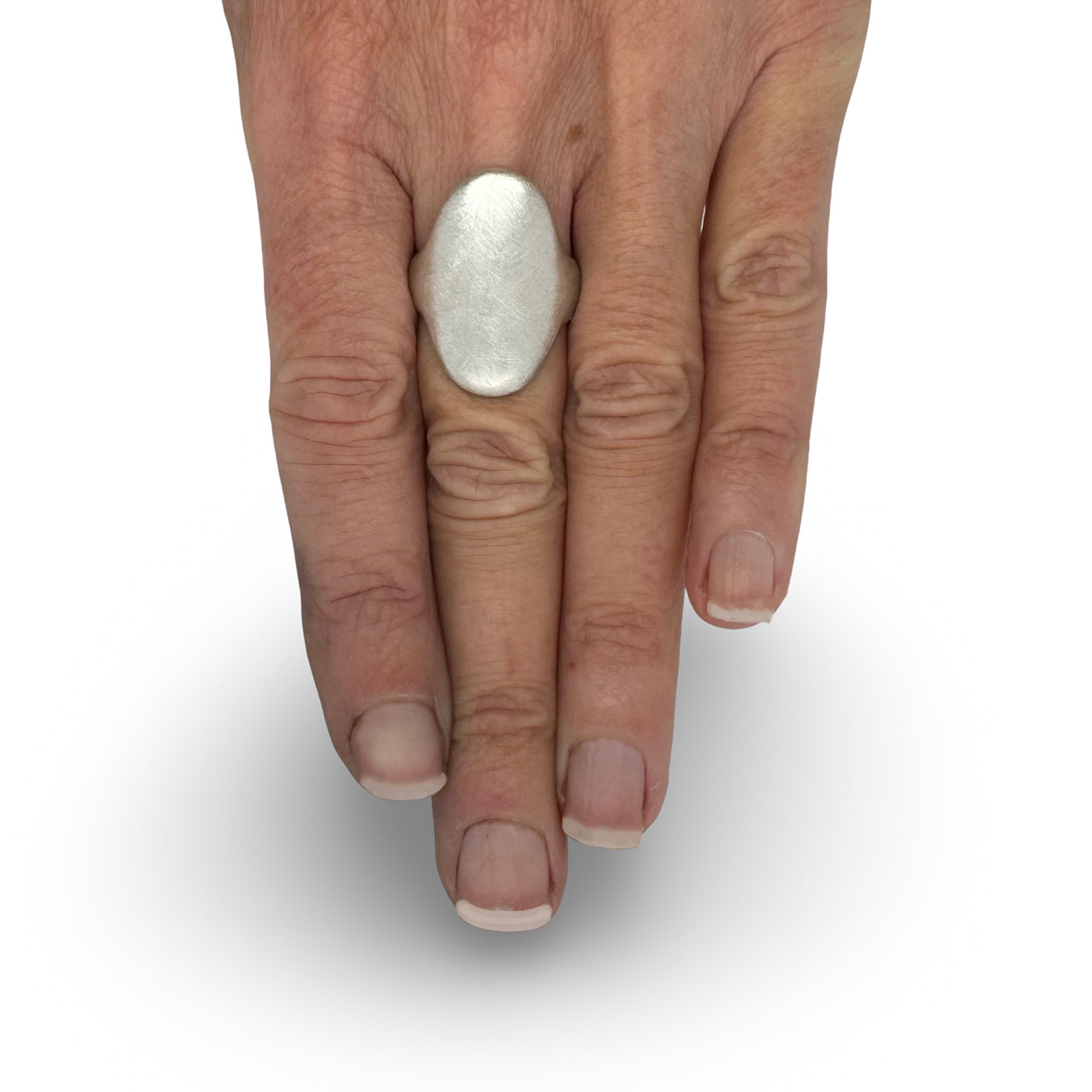 A large oval signet ring in Silver on hand. Handcrafted By Raw Jewelry Designs